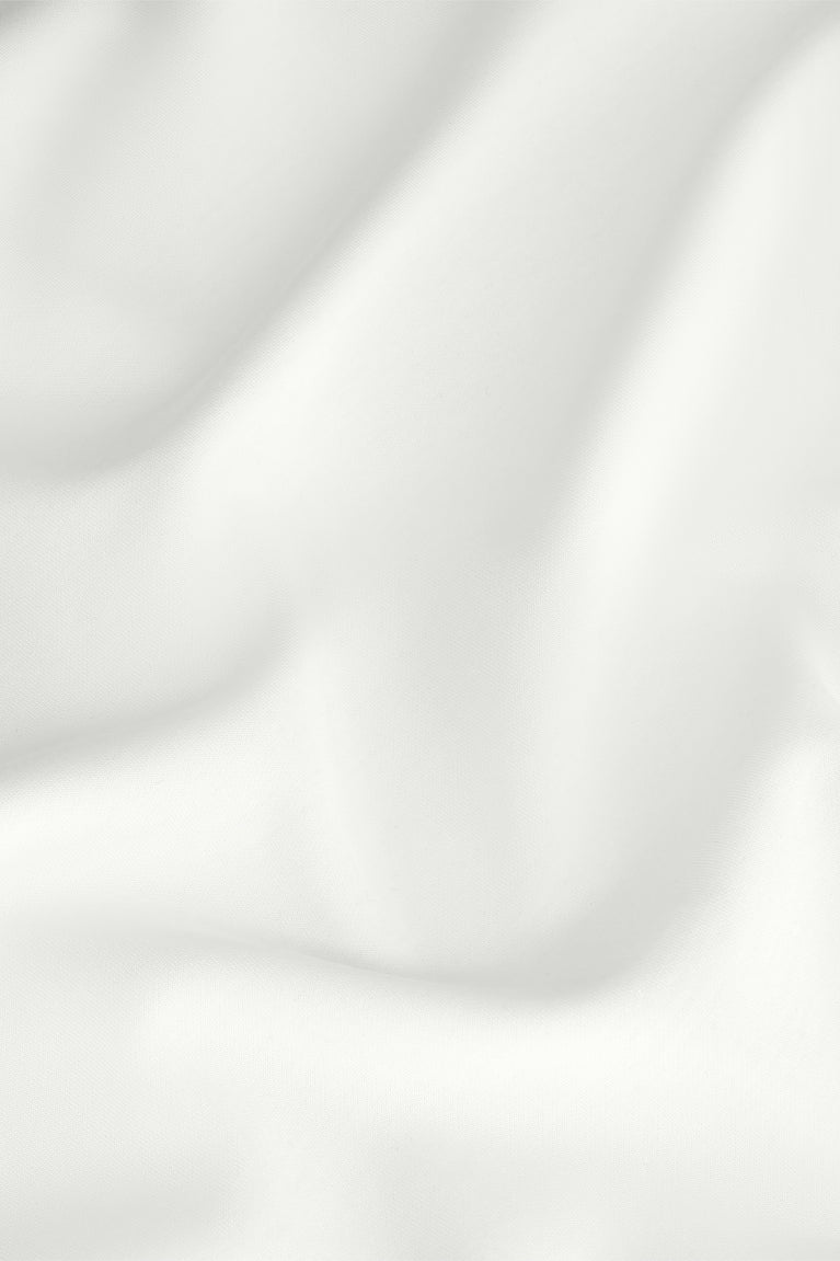 Close-up of white T-shirt fabric with soft drape and stitched seams