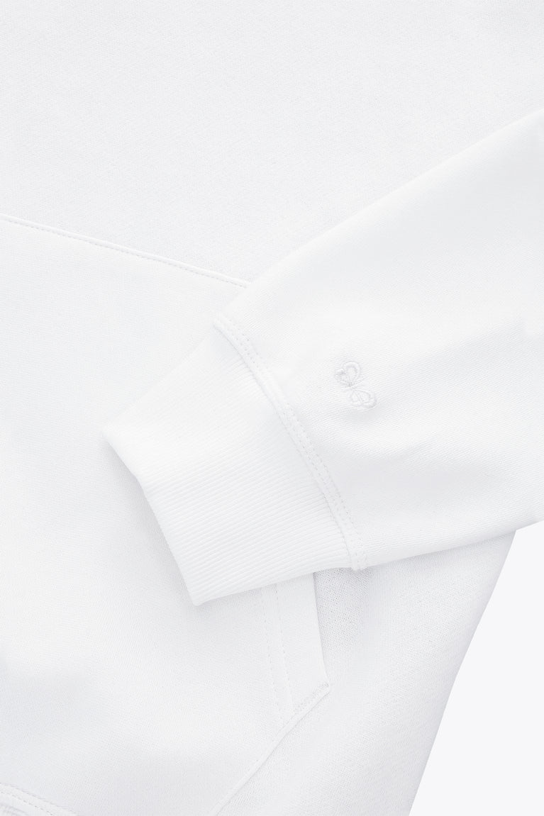 White hoodie sleeve with small embossed button style logo detail