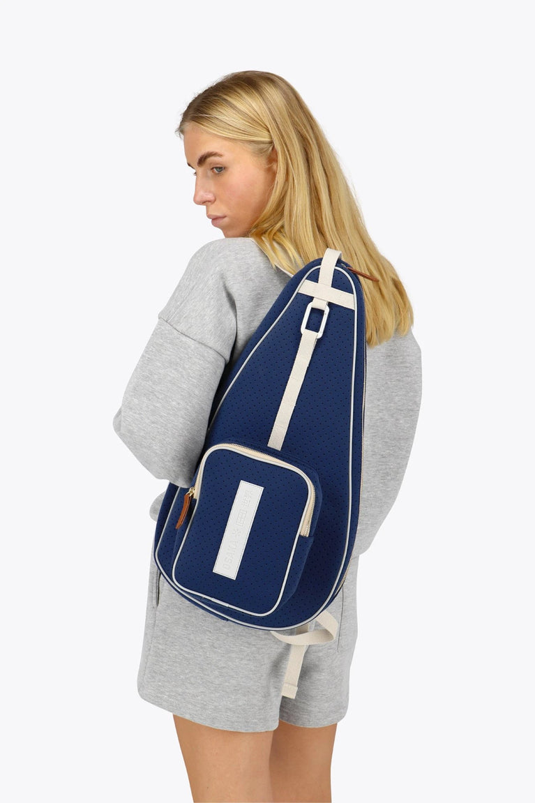 Osaka neoprene padel bag in navy with structure and logo in white. Woman wearing the bag