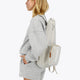 Osaka neoprene padel bag in light grey with structure and logo in white. Woman wearing the bag
