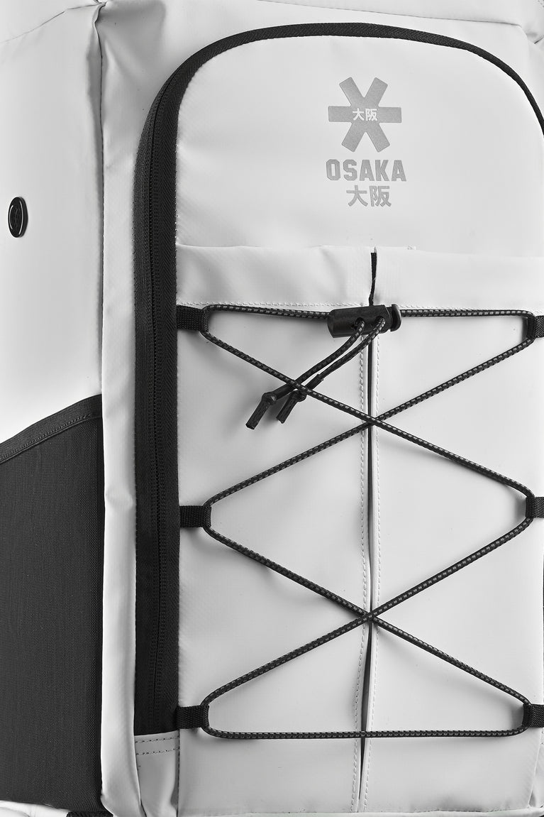 Stickbag front panel with mesh pocket and crisscross elastic straps; Osaka logo patch.