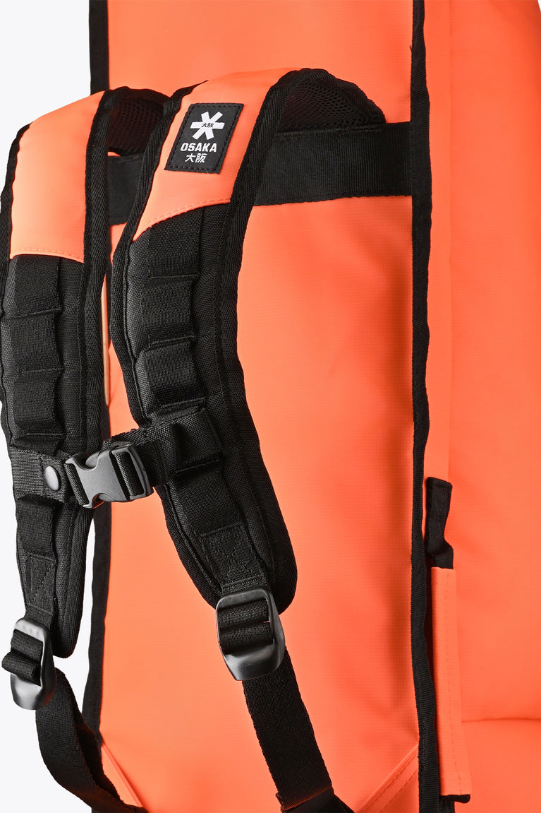 Close-up of black shoulder straps on orange stickbag, with padded webbing.
