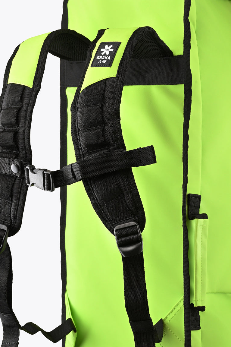 Stickbag shoulder harness with black straps and buckles on lime bag