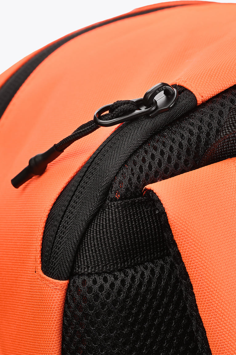 Kids sports backpack close-up: black zipper pull and mesh side panel on orange