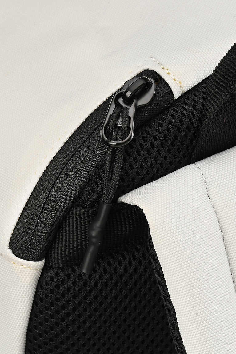 Close-up of backpack zipper and black mesh pocket detail on white fabric