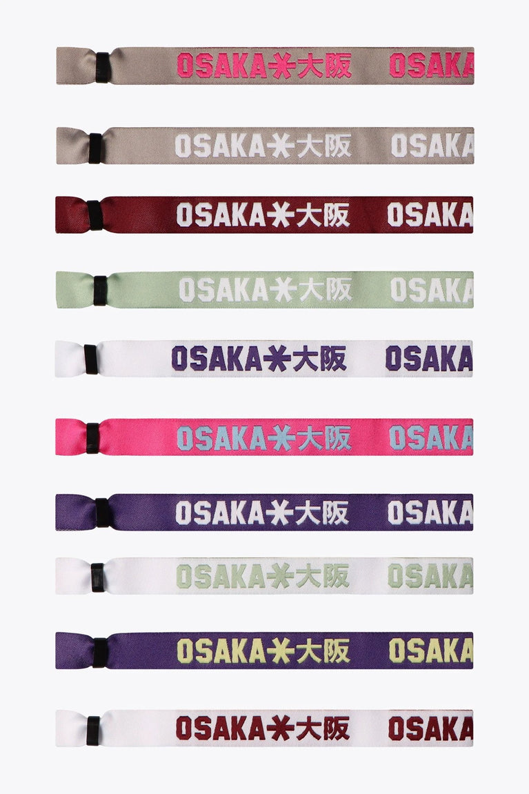A collection of Osaka woven bracelets in various colors, each featuring the text 'OSAKA 包吩工' on them.