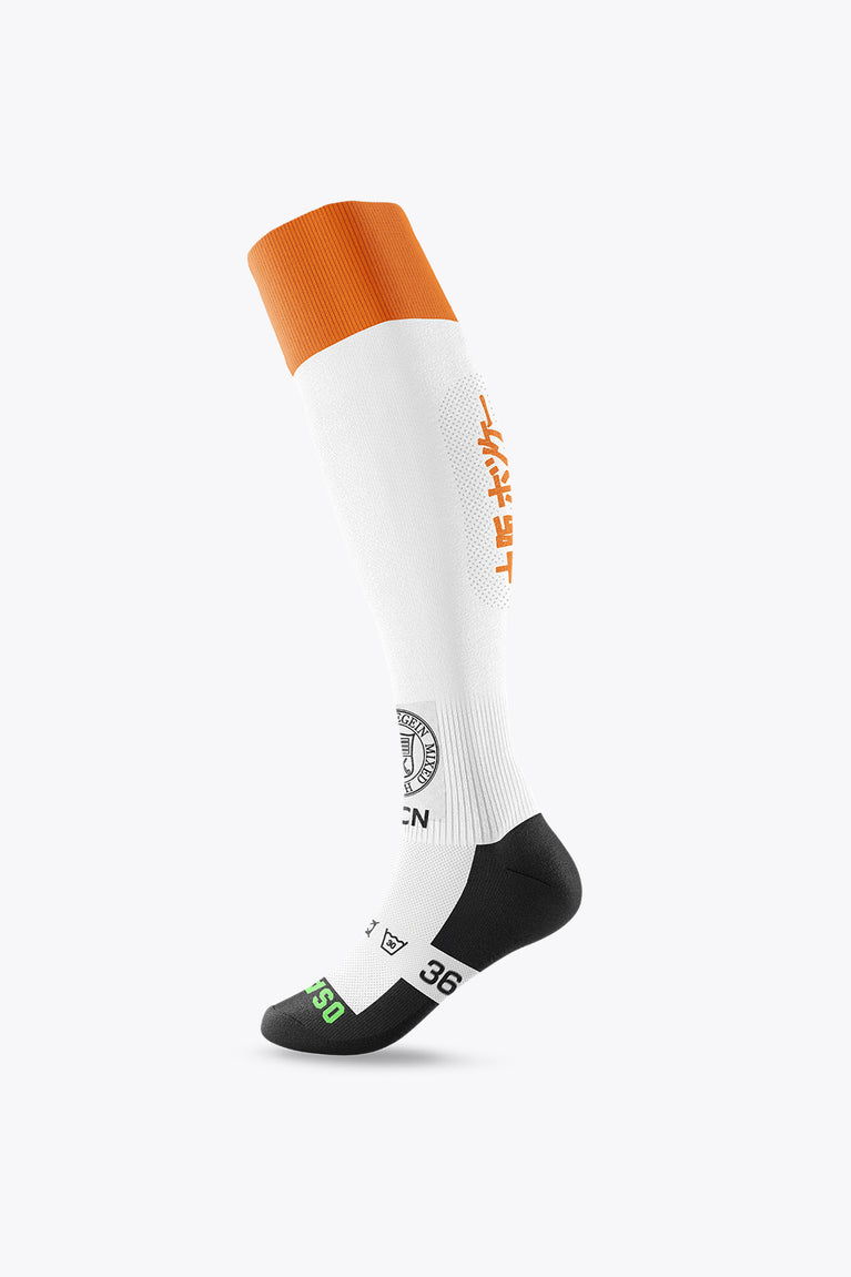 White field hockey socks with orange cuff, orange side logo, and black heel/toe