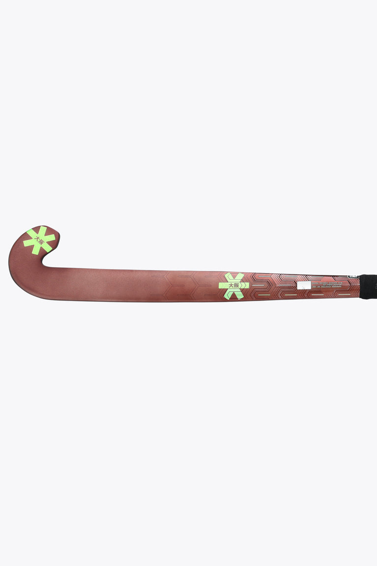 Brown field hockey stick with green star decals and black handle end.