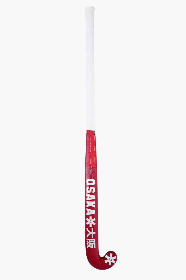 Hot pink field hockey stick with white grip, OSAKA text, and star logo near the base