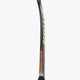 Field hockey stick upright view, dark brown shaft with green trim and black handle grip