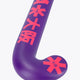 Curved royal purple hockey stick head with red graphics and starburst accents.