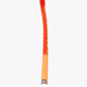 Orange field hockey stick with white grip tape at the handle end