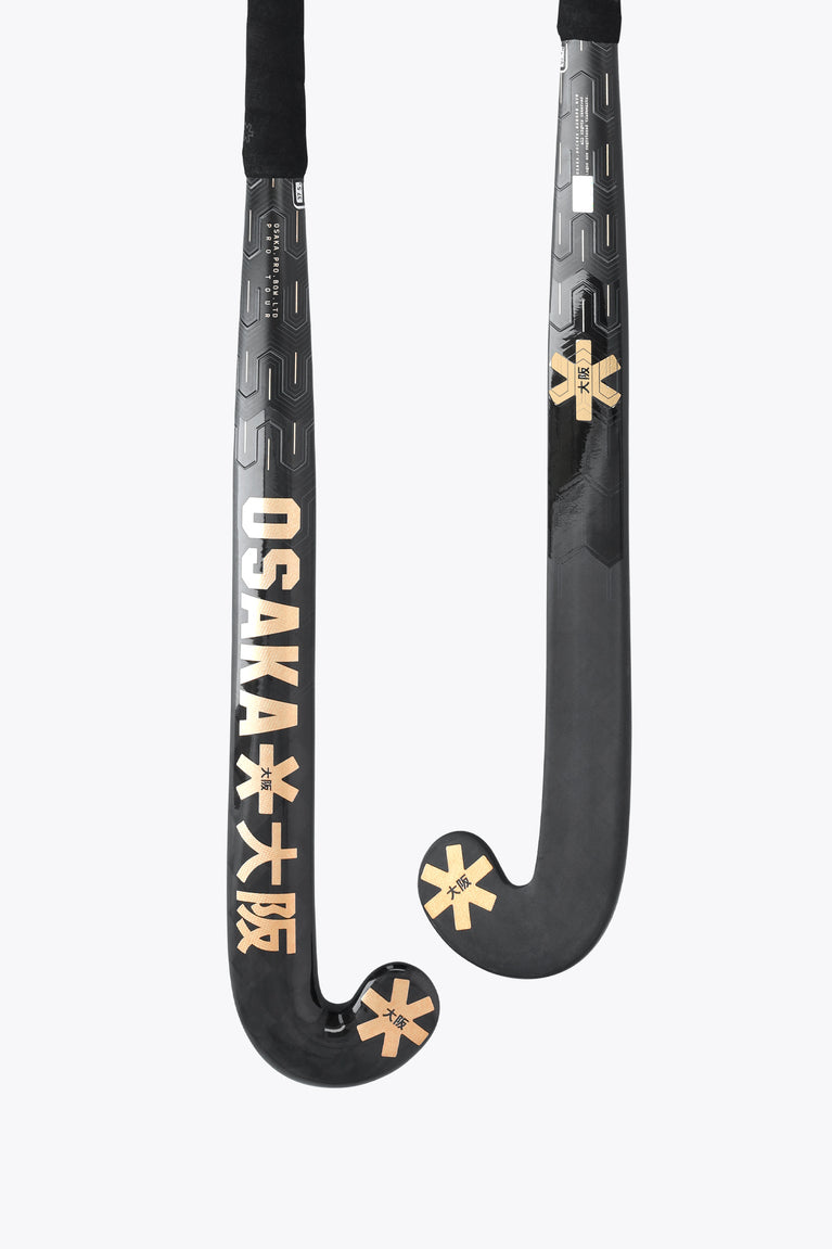 Field hockey stick with dark shaft and gold Osaka graphics on curved blade