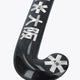 Field hockey stick blade close-up, dark black curve with Osaka branding and star emblem