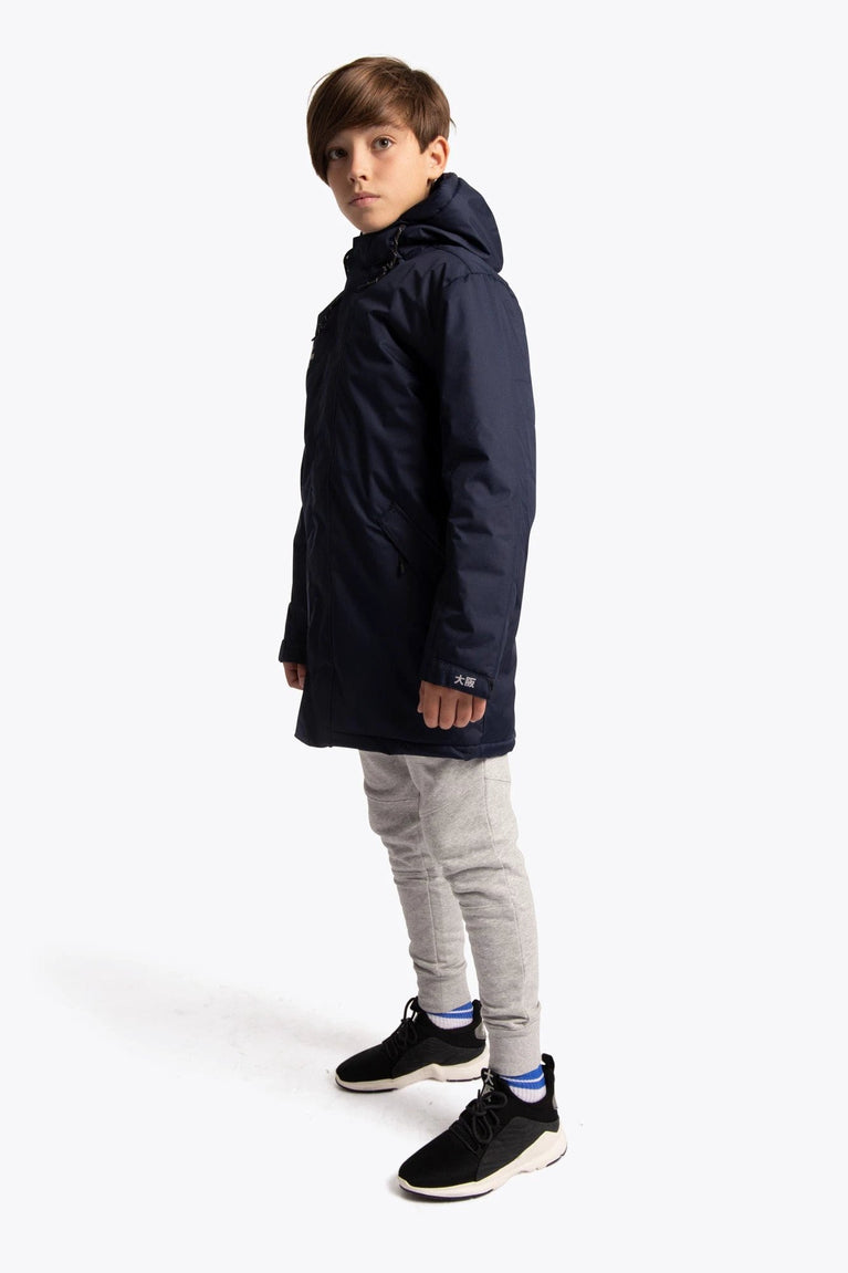 Boy wearing the Osaka Kids Stadium Jacket in Navy. Side view