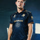Men's navy polo jersey, short sleeves, graphic crest on chest and geometric pattern