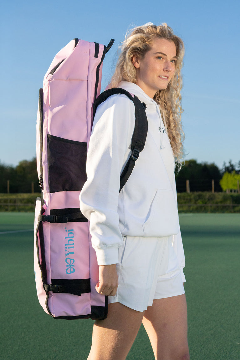 Pastel pink large hockey stick bag with black straps and front pocket