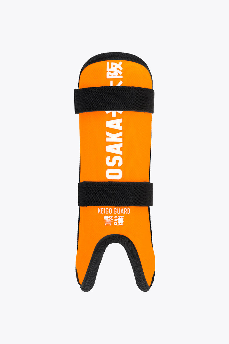 Kids shin guard in orange with black straps and logo text