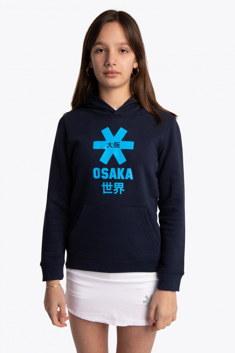 Girl wearing the Osaka kids hoodie in navy with blue star logo. Front view