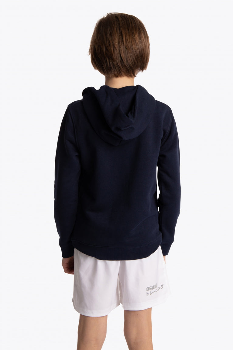 Boy wearing the Osaka kids hoodie in navy with blue star logo. Back view