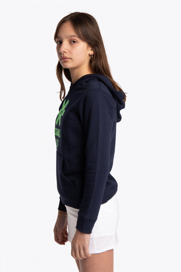 Girl wearing the Osaka kids hoodie in navy with green star logo. Side view