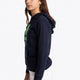 Girl wearing the Osaka kids hoodie in navy with green star logo. Side view