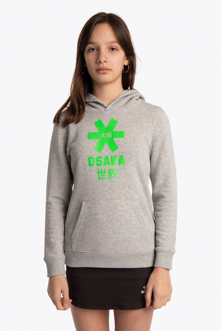 Girl wearing the Osaka kids hoodie in grey with green star logo. Front view