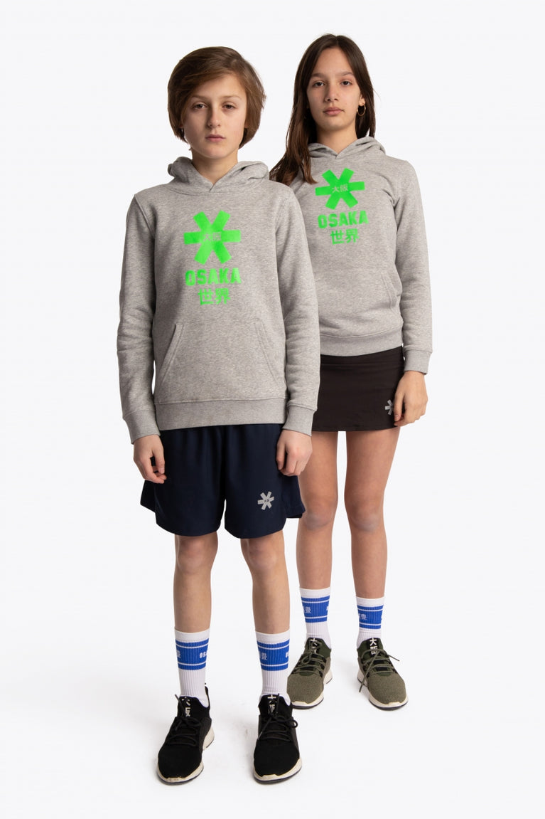 Boy and girl wearing the Osaka kids hoodie in grey with green star logo. Front full view