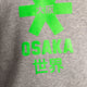Osaka kids hoodie in grey with green star logo. Detail logo view