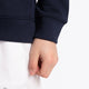 Boy wearing the Osaka kids hoodie in navy with pink star logo. Detail view sleeve