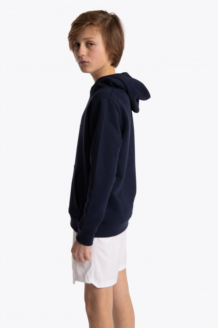 Boy wearing the Osaka kids hoodie in navy with pink star logo. Side view