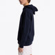 Boy wearing the Osaka kids hoodie in navy with pink star logo. Side view