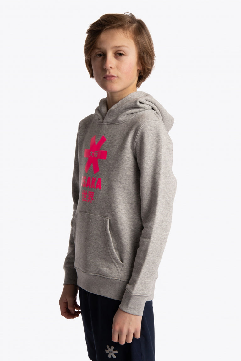 Boy wearing the Osaka kids hoodie in grey with pink star logo. Front/side view