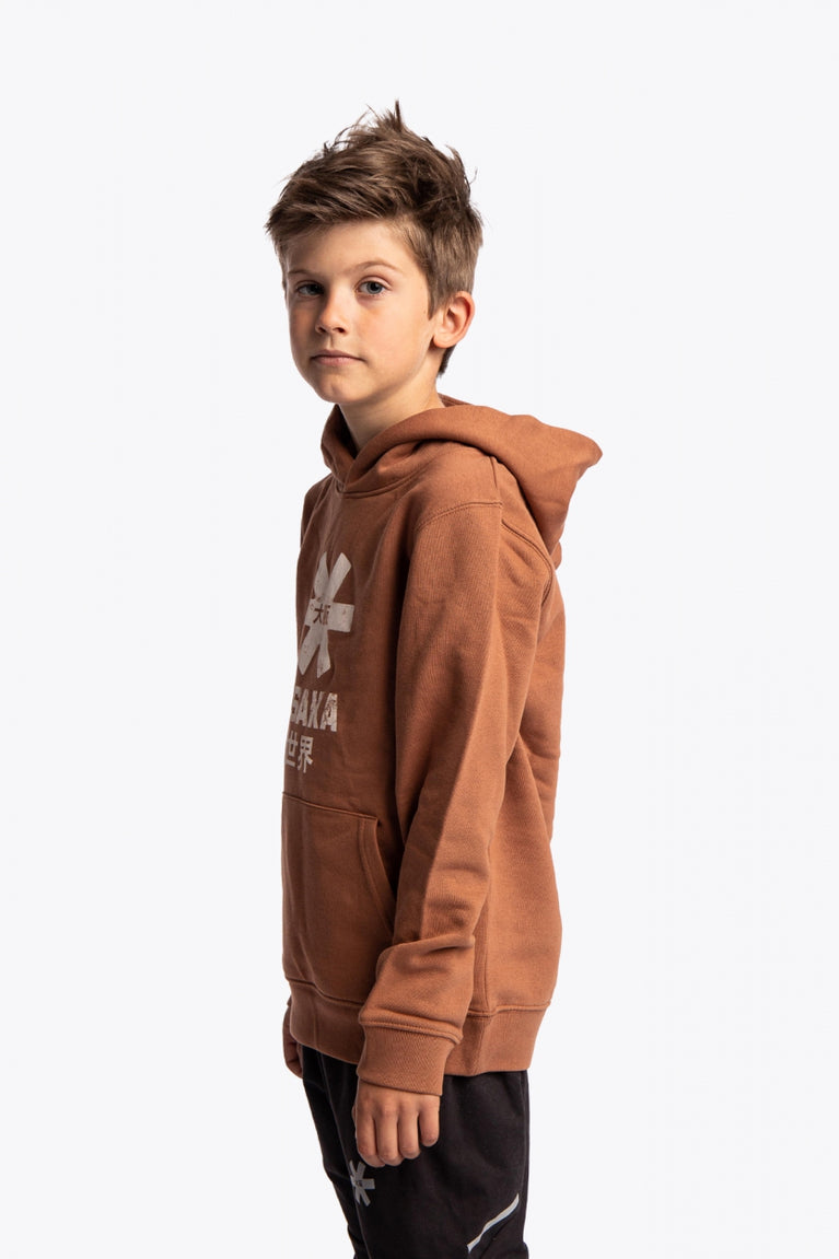 Boy wearing the Osaka kids vintage hoodie in caramel with logo in white. Side/front view