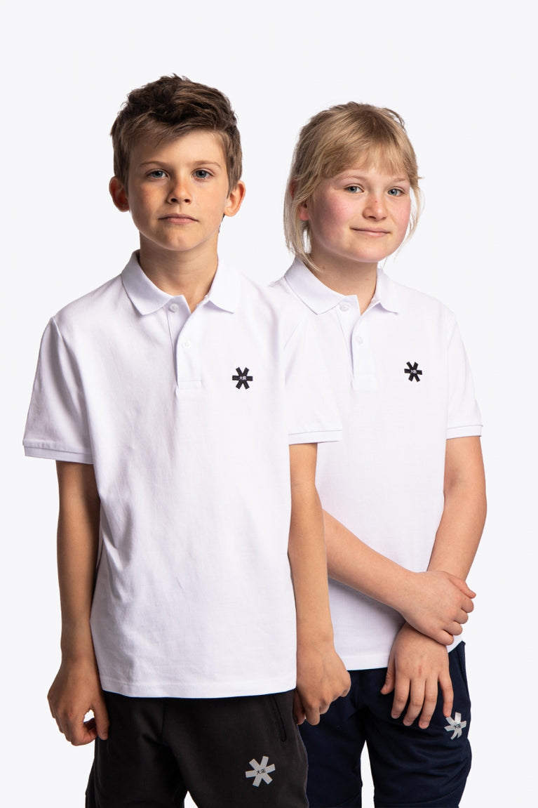 Boy and girl wearing the Osaka kids polo in white with logo in black. Front view