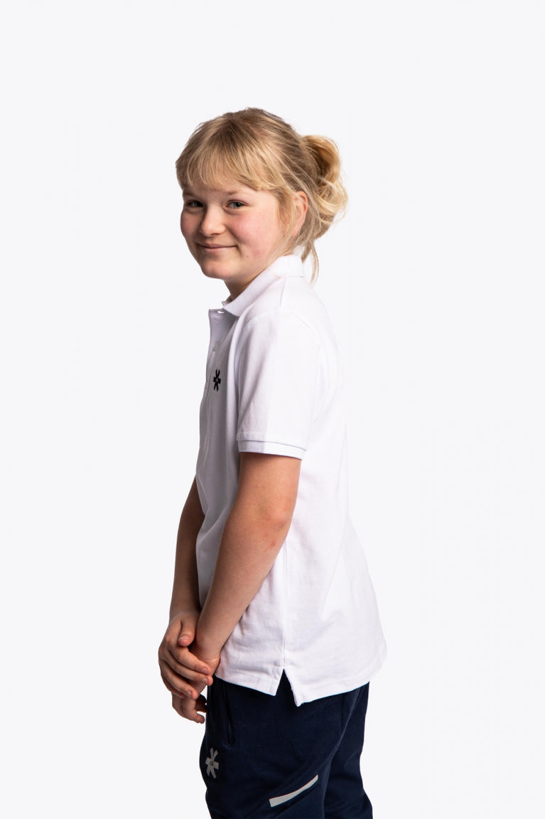 Girl wearing the Osaka kids polo in white with logo in black. Side view