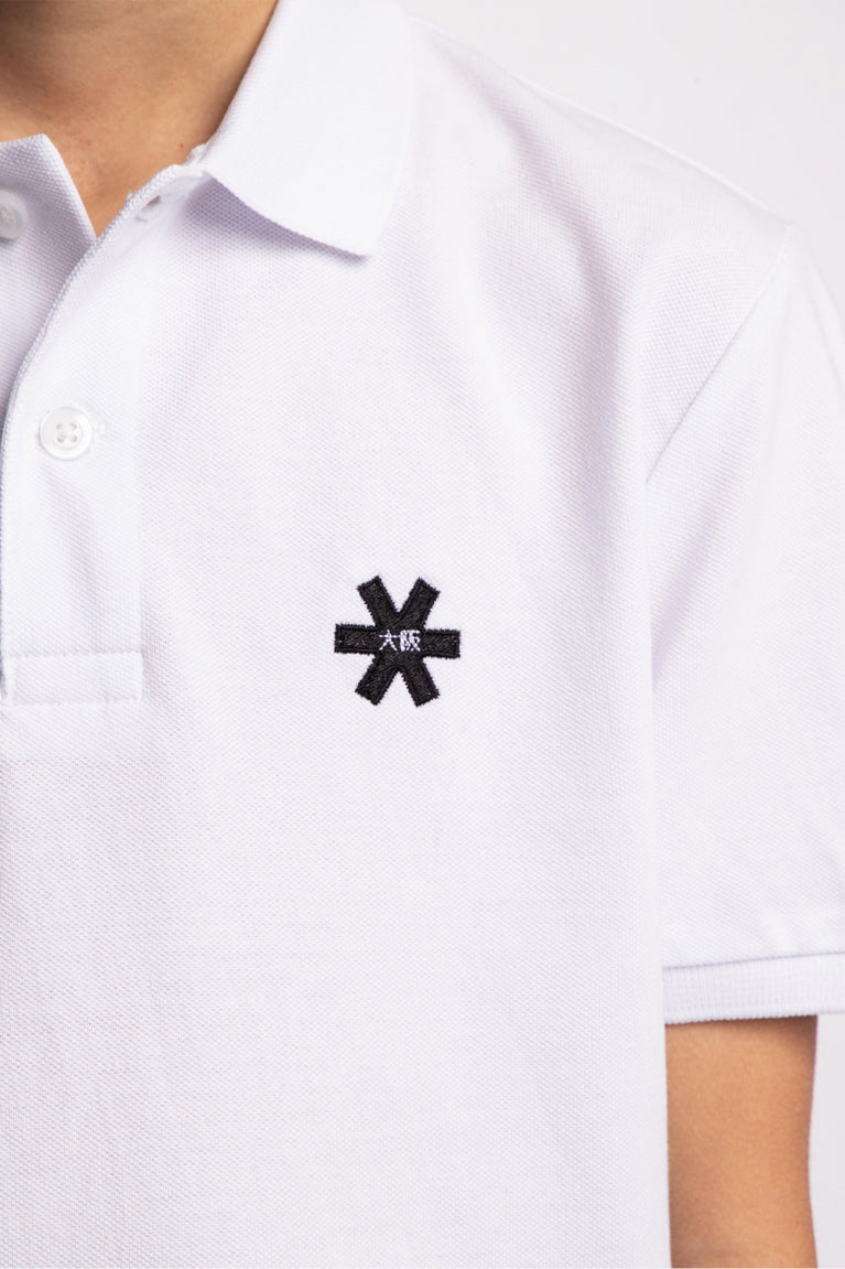 Osaka kids polo in white with logo in black. Detail view logo