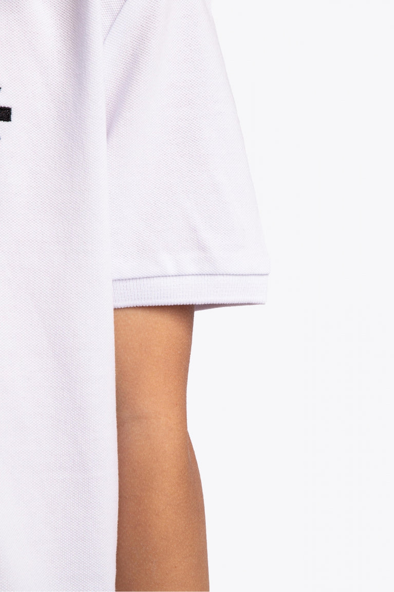 Osaka kids polo in white with logo in black. Detail view sleeve