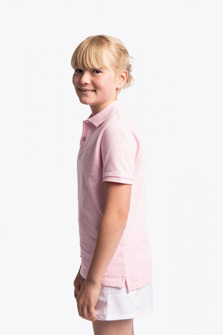 Girl wearing the Osaka kids polo in cotton pink with logo in white. Side view