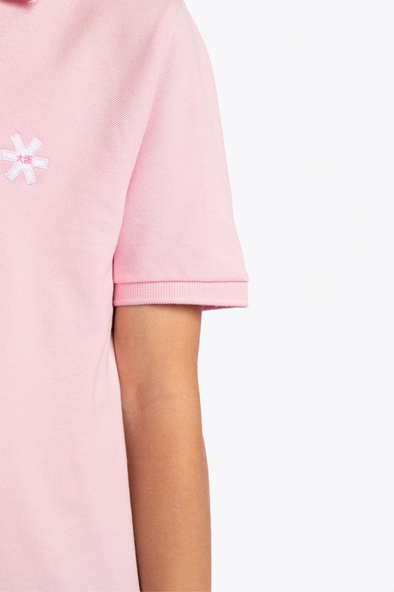 Osaka kids polo in cotton pink with logo in white. Detail view shoulder