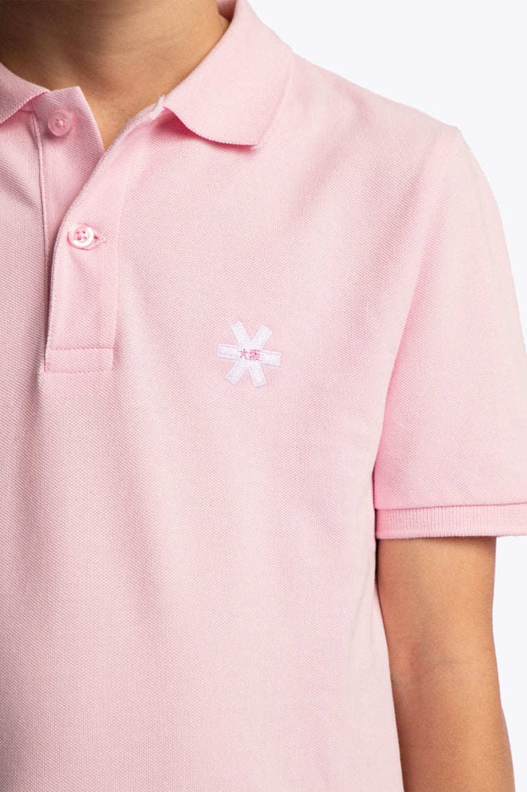 Osaka kids polo in cotton pink with logo in white. Detail view logo