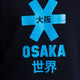 Osaka kids sweater in navy with logo in blue. Detail view logo