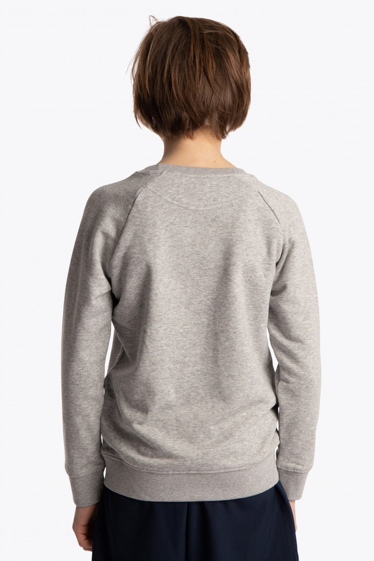 Boy wearing the Osaka kids sweater in grey with logo in blue. Back view