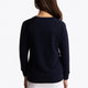 Girl wearing the Osaka kids sweater in navy with logo in green. Back view