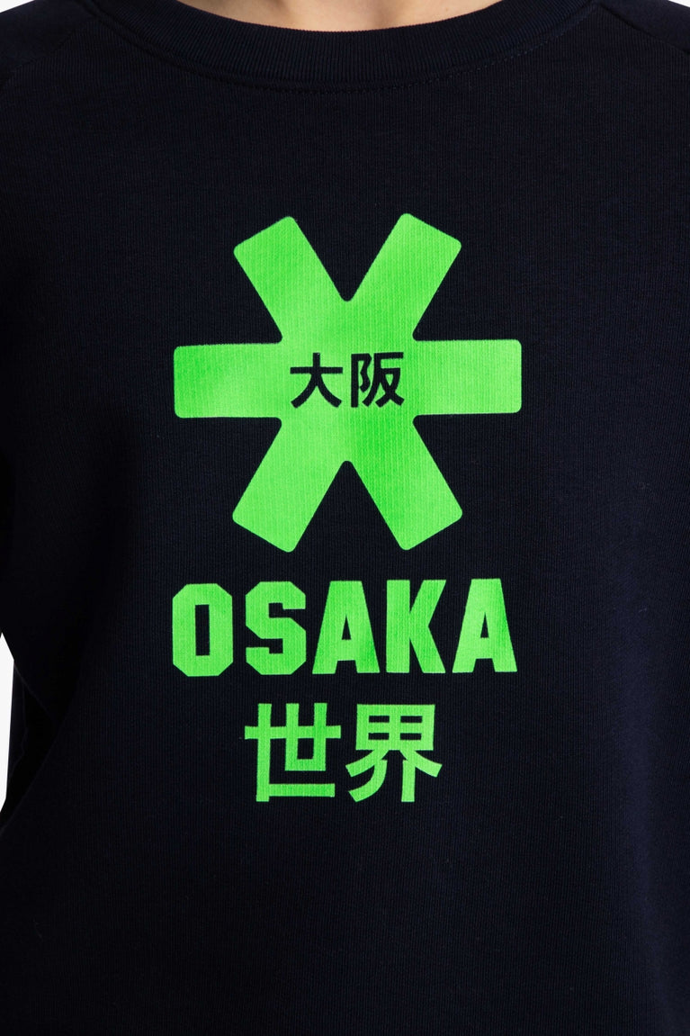 Osaka kids sweater in navy with logo in green. Detail view logo