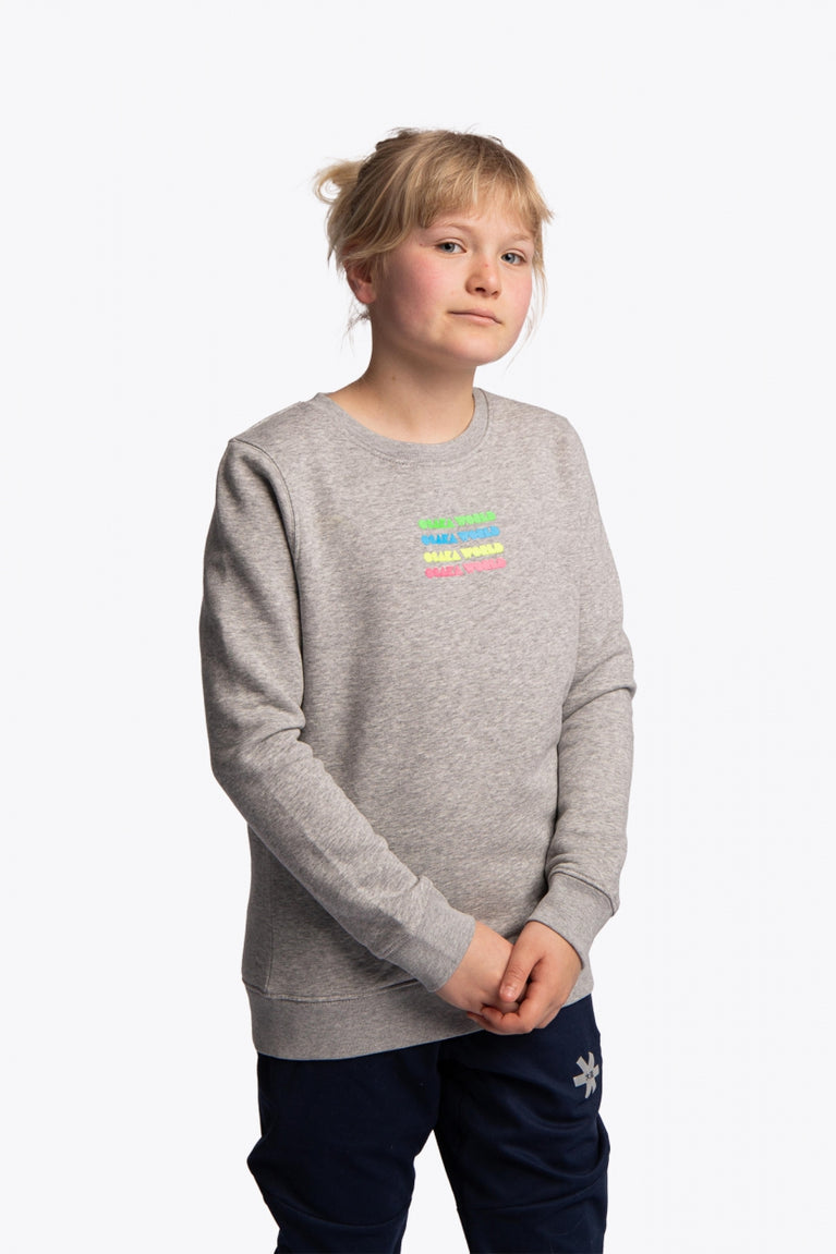 Girl wearing the Osaka kids pacs sweater in navy with multicolor logo pac-man style. Front view