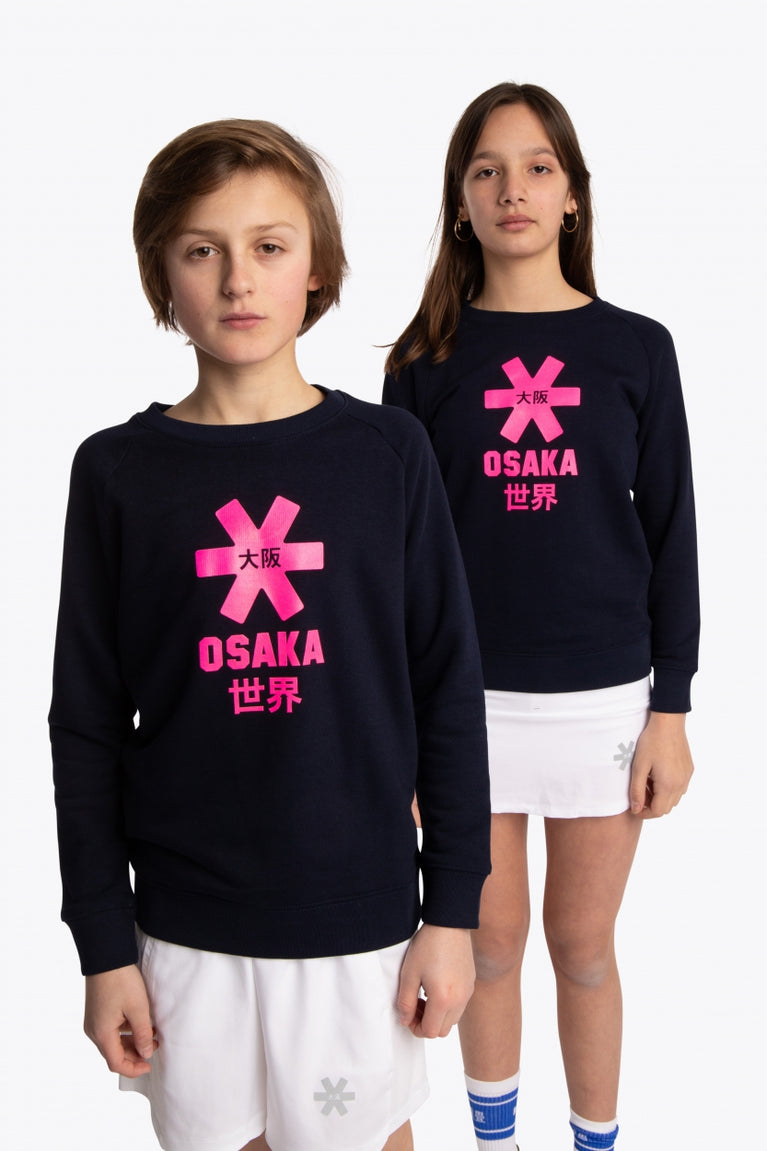 Boy and girl wearing the Osaka kids sweater in navy with pink logo. Front view