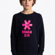 Boy wearing the Osaka kids sweater in navy with pink logo. Front view