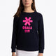 Girl wearing the Osaka kids sweater in navy with pink logo. Front view