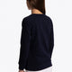 Girl wearing the Osaka kids sweater in navy with pink logo. Side/back view